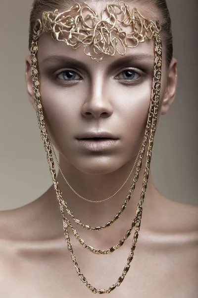 Hermosa chica con una piel de bronce, maquillaje pálido y accesorios inusuales. Arte belleza imagen. Cara de belleza . — Foto de Stock