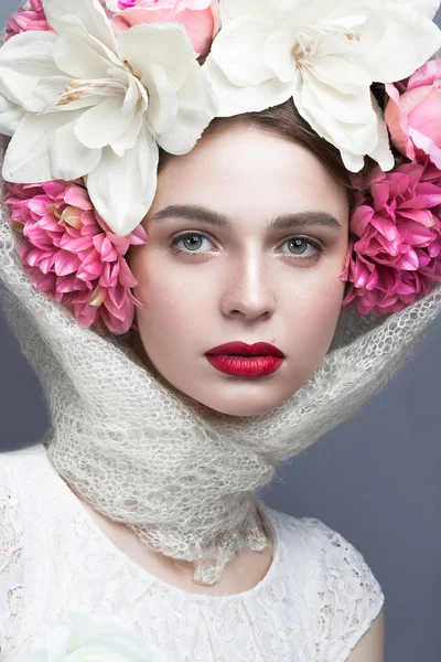 Hermosa chica en un pañuelo en la cabeza en el estilo ruso, con grandes flores en la cabeza y labios rojos. Cara de belleza . — Foto de Stock