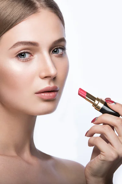 Mooi meisje met een lichte natuurlijke make-up en schoonheid tools in de hand. — Stockfoto