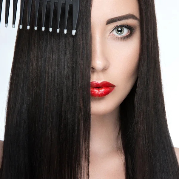 Schöne brünette Mädchen mit einem perfekt glatten Haar, Haarbürste und klassischem Make-up. Schönheit Gesicht. — Stockfoto