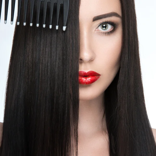 Menina morena bonita com um cabelo perfeitamente liso, escova de cabelo e maquiagem clássica. Cara de beleza . — Fotografia de Stock