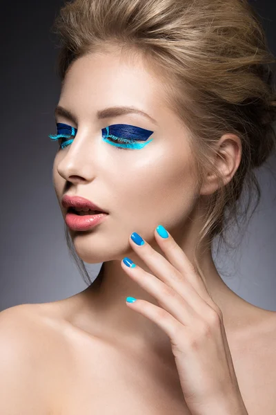 Vacker tjej med ljusa creative mode makeup och blått nagellack. Konst skönhet design. — Stockfoto