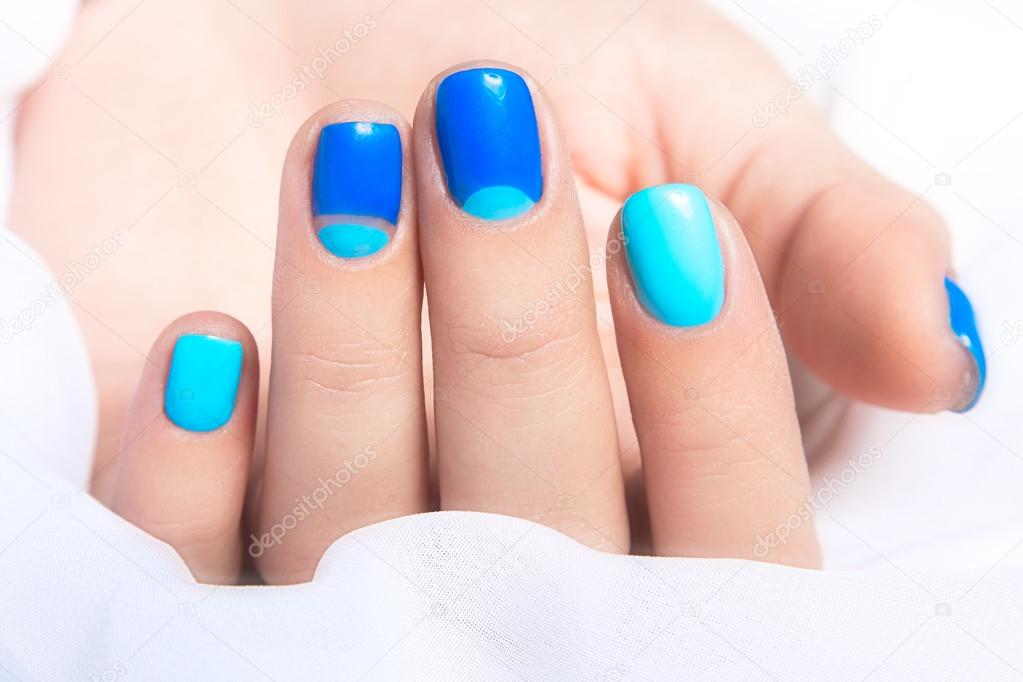 Blue manicure in light and dark colors of lacquer on a white background.