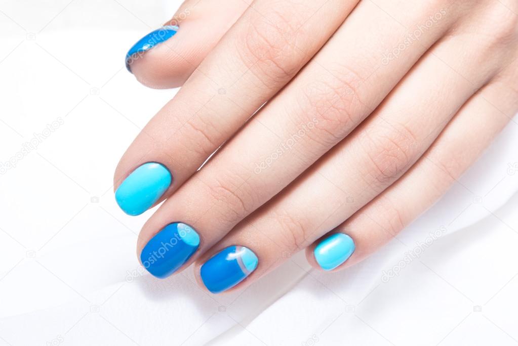 Blue manicure in light and dark colors of lacquer on a white background.