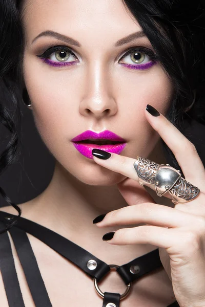 Hermosa chica en el estilo gótico con accesorios de cuero y maquillaje brillante . — Foto de Stock