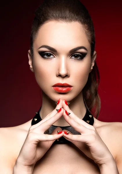 Hermosa mujer de estilo gótico, maquillaje de noche y uñas rojas con espinas . — Foto de Stock