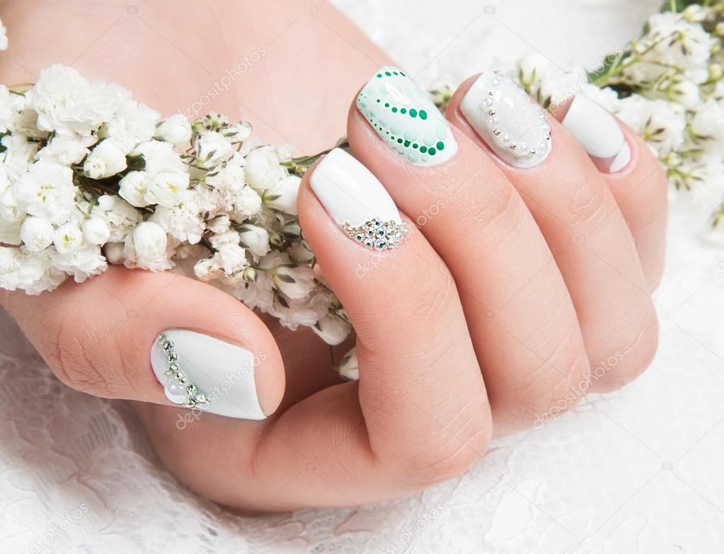 Wedding manicure for the bride in gentle tones with flowers. Nail Design. Close-up.