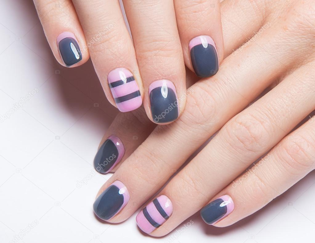 Beautiful womens manicure with gray and pink polish on the nails