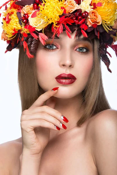 Schönes Mädchen mit hellem Herbstkranz aus Blättern und Blumen. Schönheit Gesicht. Foto aus dem Studio auf weißem Hintergrund. — Stockfoto