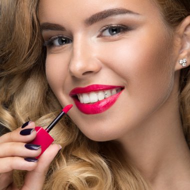 Kıvırcık, kırmızı dudaklar ve onun yüzünde bir gülümseme ile güzel sarışın kız.