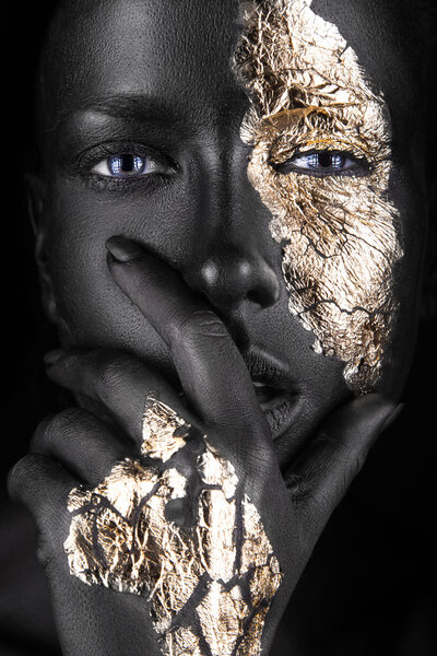 fashion portrait of a dark-skinned girl with gold make-up. Beauty face.