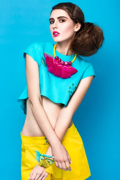 Belle femme à la mode une coiffure inhabituelle dans des vêtements lumineux et des accessoires colorés. Style cubain . — Photo