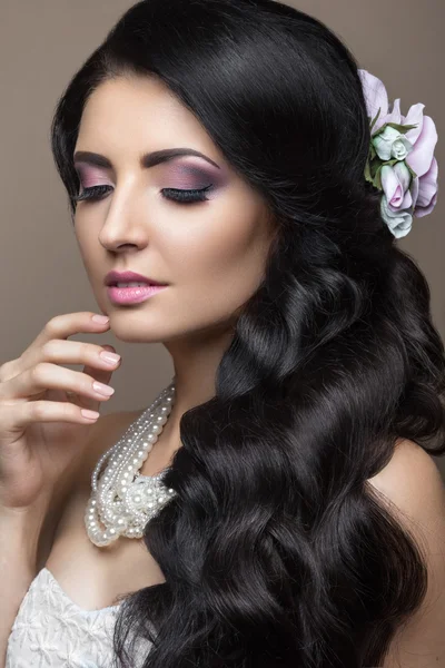 Schöne brünette Frau im Bild der Braut mit Blumen. Schönheit Gesicht und Frisur — Stockfoto