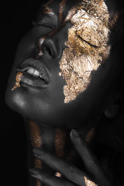 Modeportret van een donker meisje met gouden make-up. Schoonheidsgezicht. — Stockfoto