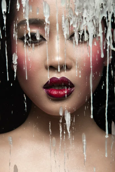 Krásná Asiatka s světlý make-up za sklo a kapky vosku. Krása obličej. — Stock fotografie