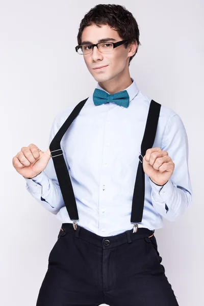 Bel giovanotto allegro con gli occhiali, camicia con le bretelle e una farfalla sul collo. Persone emotive . — Foto Stock