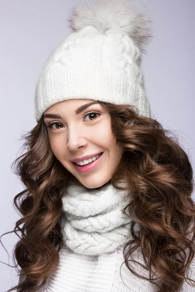 Hermosa chica con maquillaje suave, rizos y sonrisa en sombrero de punto blanco. Imagen de invierno cálido. Rostro de belleza. — Foto de Stock