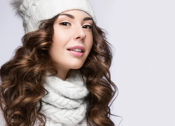 Menina bonita com maquiagem suave, cachos e sorriso em chapéu de malha branca. Imagem quente do inverno. Cara de beleza . — Fotografia de Stock