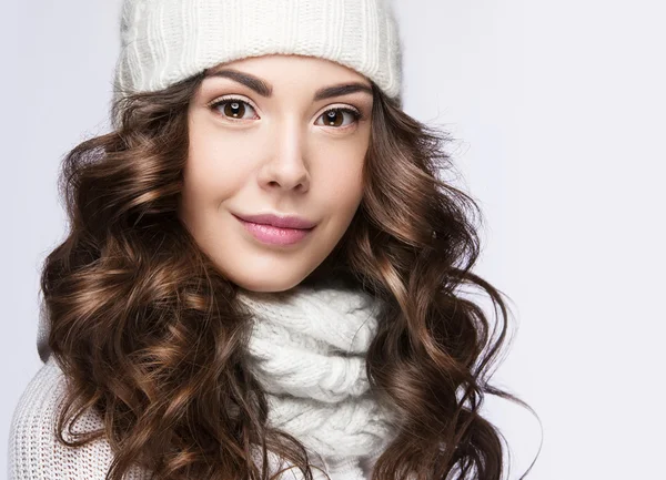 美丽的姑娘，温柔的化妆，卷发和微笑的白色针织帽。温暖的冬天图像。美丽的脸. — 图库照片