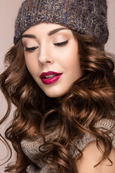 Menina bonita com maquiagem suave, cachos em chapéu de malha marrom. Imagem quente do inverno. Cara de beleza . — Fotografia de Stock