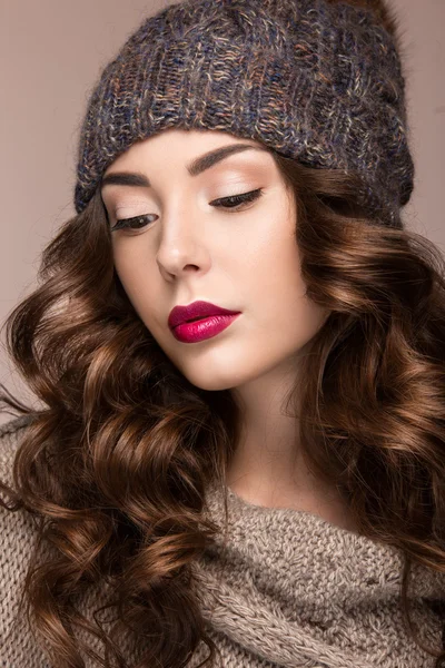 Schönes Mädchen mit sanftem Make-up, Locken in brauner Strickmütze. warmes Winterbild. Schönheit Gesicht. — Stockfoto