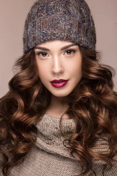Vacker flicka med mild makeup, lockar i brun stickad hatt. Varm vinter bild. Skönhet ansikte. — Stockfoto