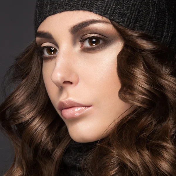 Hermosa chica con maquillaje Smokey, rizos en sombrero de punto negro. Imagen cálida de invierno. Cara de belleza . —  Fotos de Stock