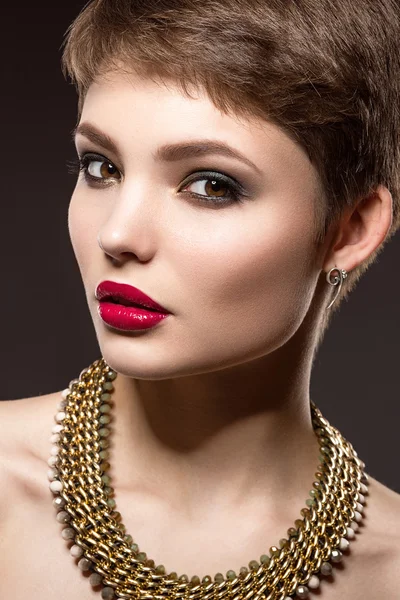 Vacker brunett kvinna med perfekt hud, ljusa makeup och guldsmycken. Skönhet ansikte. — Stockfoto