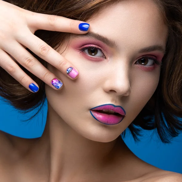 Hermosa chica modelo con maquillaje brillante y esmalte de uñas de colores. Cara de belleza. Clavos cortos de colores — Foto de Stock