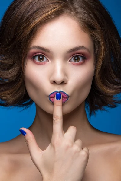 Hermosa chica modelo con maquillaje brillante y esmalte de uñas de colores. Cara de belleza. Clavos cortos de colores — Foto de Stock