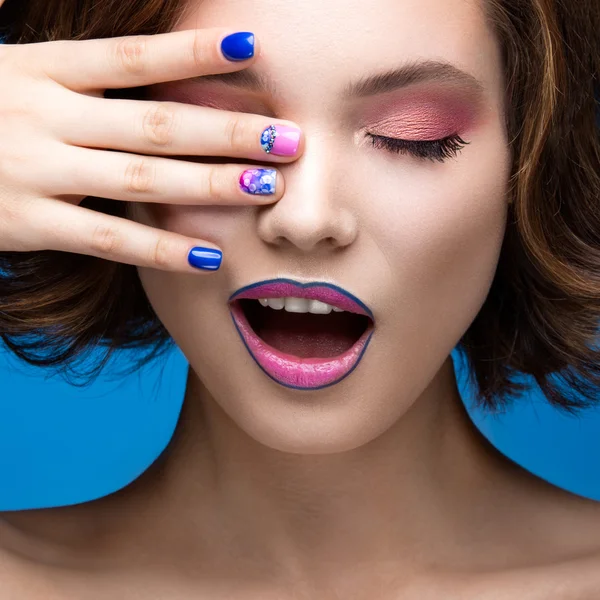 Hermosa chica modelo con maquillaje brillante y esmalte de uñas de colores. Cara de belleza. Clavos cortos de colores — Foto de Stock