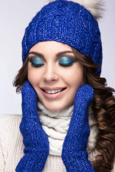 Menina bonita com maquiagem suave, cachos e sorriso em chapéu de malha azul. Imagem quente do inverno. Cara de beleza . — Fotografia de Stock