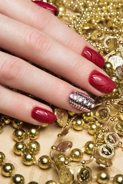 Beautiful red manicure with crystals on female hand. Close-up. — Stock Photo, Image