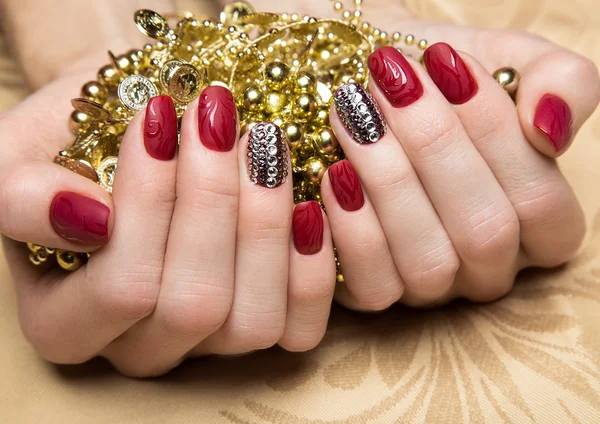 Manicure vermelho bonito com cristais na mão feminina. Close-up . — Fotografia de Stock