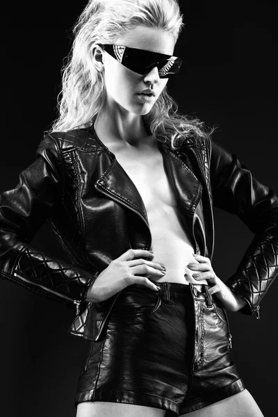 Modelo atrevida chica en gafas de sol de moda, ropa de cuero negro en el cuerpo desnudo, maquillaje oscuro, cabello mojado. estilo rock. Imagen en blanco y negro . — Foto de Stock