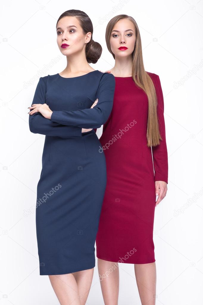 Two Pretty girls in fashionable stylish clothes, on a white background. Beauty, fashion, style.