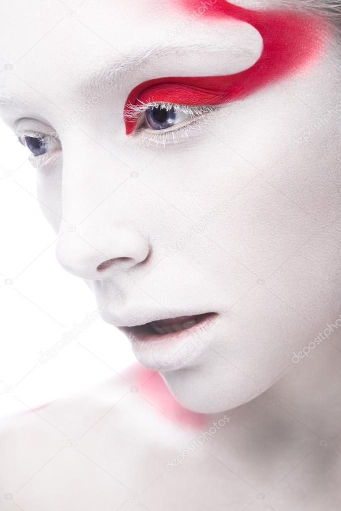 Art fashion girl with white skin and red paint on the face. Creative art beauty.