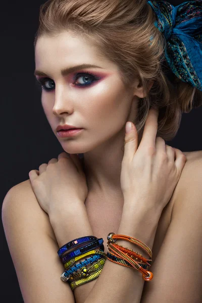 Beautiful fashion girl in a scarf and bracelets boho style. Beauty face, bright trendy makeup. — Stock Photo, Image