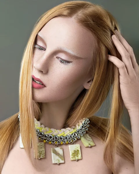 Gyönyörű vörös hajú lány, szeplő, a hosszú, egyenes haj és a nyaka köré egy nyaklánc. Szépség arc. — Stock Fotó