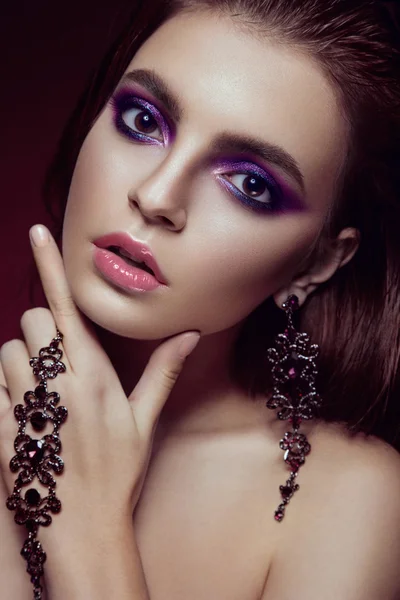Hermosa chica con maquillaje púrpura brillante y joyas. Cara de belleza . — Foto de Stock