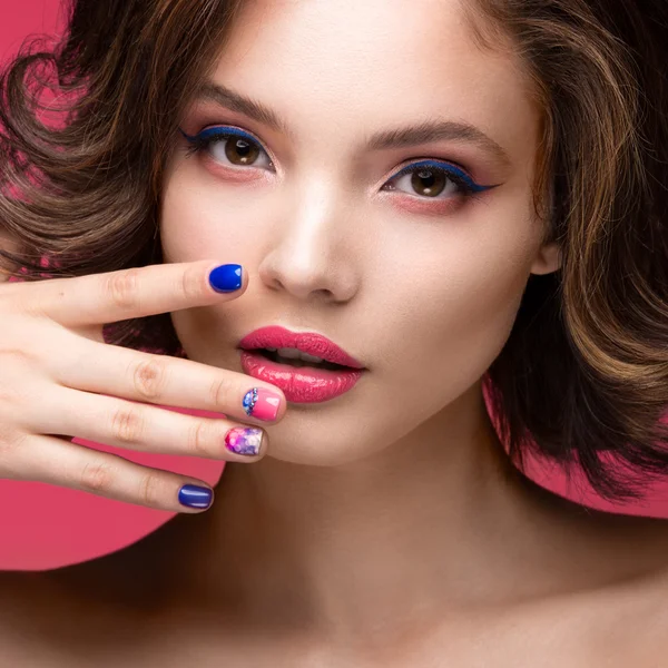 Hermosa chica modelo con maquillaje rosa brillante y esmalte de uñas de colores. Cara de belleza. Clavos cortos de colores — Foto de Stock