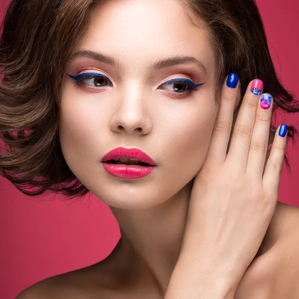 Hermosa chica modelo con maquillaje rosa brillante y esmalte de uñas de colores. Cara de belleza. Clavos cortos de colores — Foto de Stock