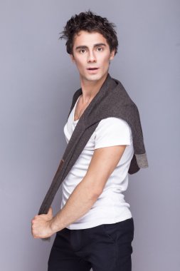 Yakışıklı tarzı. Neşeli genç adam akıllı casual giyim kamera duygusal insanlara bakmaktan.