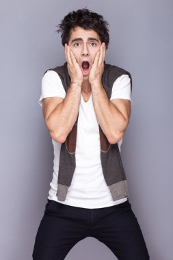 Yakışıklı tarzı. Neşeli genç adam akıllı casual giyim kamera duygusal insanlara bakmaktan.