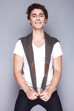 Yakışıklı tarzı. Neşeli genç adam akıllı casual giyim kamera duygusal insanlara bakmaktan.