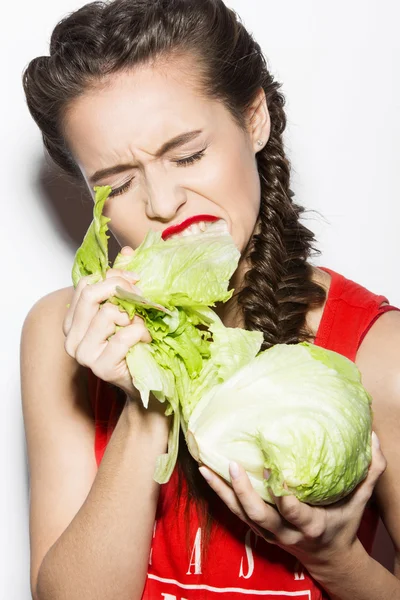 Chica divertida atrevida con trenzas y labios rojos, comer repollo emocional. Belleza emoción cara . —  Fotos de Stock