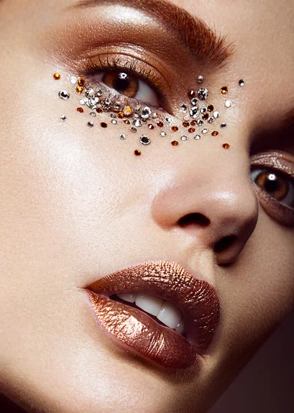 Mooi meisje met een zachte make-up en kristallen op het gezicht. Close-up portret. — Stockfoto