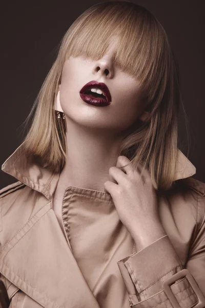 Beautiful blonde woman in a bright coat and dark lips, showing different poses. Beauty face. — Stock Photo, Image