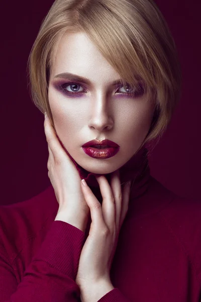 Vacker blond kvinna i en röd tröja med ljusa makeup och mörka läppar. Skönhet ansikte. — Stockfoto