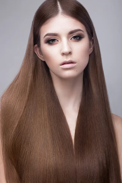 Hermosa chica morena con un pelo perfectamente liso y maquillaje clásico. Cara de belleza . Fotos de stock libres de derechos